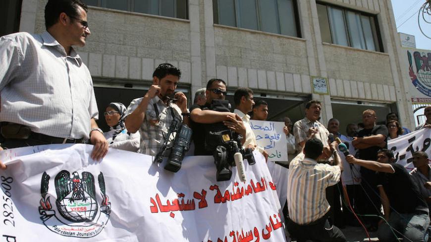 Palestinian journalists protest in front of the Journalists' Syndicate in Gaza City 26 August 2007. Dozens of journalists staged a sit-in in Gaza today, protesting against pressure on the media by the Islamist Hamas movement that took over the territory in mid-June. More than 100 reporters gathered in front of the journalists union building in central Gaza City, two days after Hamas forces briefly detained four journalists and violently broke up a rally of the rival Fatah party. AFP PHOTO/MAHMUD HAMS (Photo