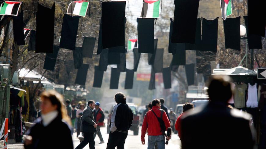 Pedestrians walk along a street decorated with black and Palestine flags next to an orthodox church in the Patronato neighbourhood in Santiago August 7, 2006, where members of the Palestinian community attended a mass against Israel's military offensive in Lebanon and Gaza. REUTERS/Ivan Alvarado (CHILE) - RTR1G6L1