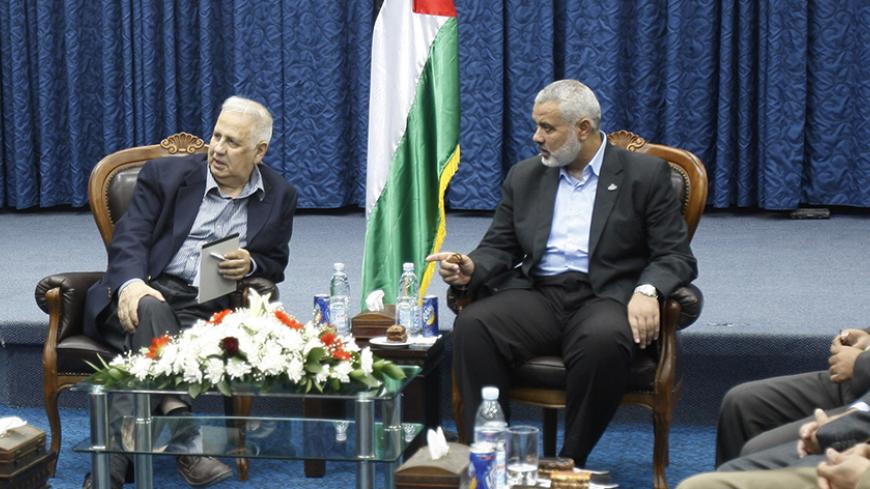 Hamas prime minister in Gaza Ismail Haniyeh (R) gestures during a meeting with Hanna Nasir (L), chairman of the Palestinian Central Election Commission (CEC), and the commission members in Gaza City May 28, 2012. Palestinian President Mahmoud Abbas's Fatah faction and Palestinian Islamist group Hamas began talks to form a unity government on Monday in a renewed bid to heal political rifts, paving the way for a general election. REUTERS/ Ibraheem Abu Mustafa (GAZA - Tags: POLITICS) - RTR32QWC