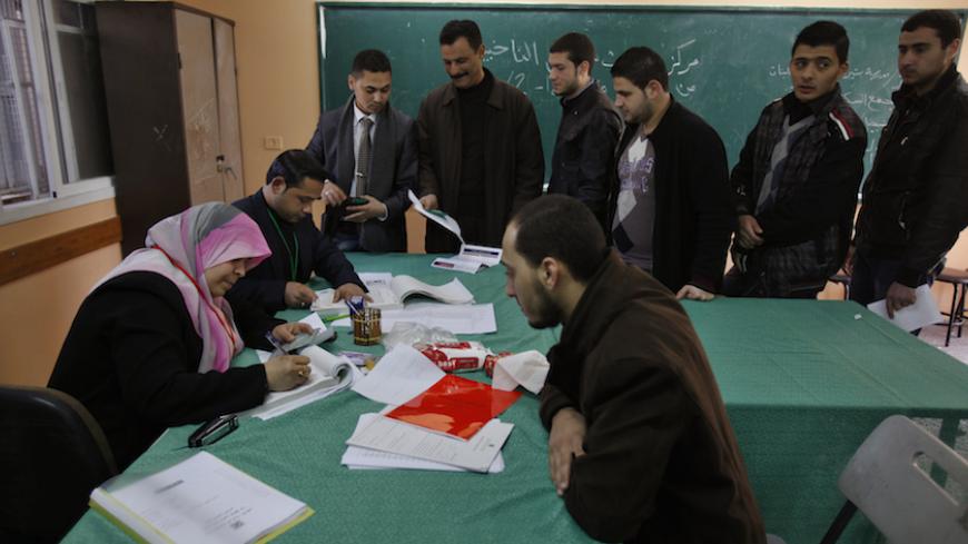 Palestinians update their details at a centre run by the Palestinian Central Election Commission (CEC), in Gaza City February 11, 2013.The Palestinian Central Election Commission on Monday began registering voters in Gaza and the West Bank for an upcoming election hoped to help with healing nearly six years of political rifts among rival factions.  REUTERS/Ibraheem Abu Mustafa (GAZA - Tags: POLITICS ELECTIONS) - RTR3DMR0