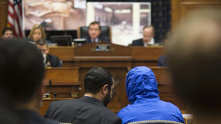 ATTENTION EDITORS - VISUAL COVERAGE OF SCENES OF INJURY OR DEATH
The man credited with smuggling 50,000 photos said to document Syrian government atrocities, a Syrian Army defector known by the protective alias Caesar (disguised in a hooded blue jacket), listens to his interpreter as he prepares to speak at a briefing to the House Foreign Affairs Committee on Capitol Hill in Washington July 31, 2014. REUTERS/Jonathan Ernst (UNITED STATES - Tags: POLITICS MILITARY CONFLICT) TEMPLATE OUT - RTR40T2R