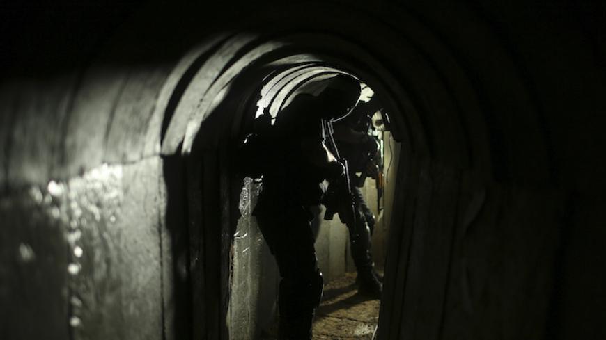 Palestinian fighters from the Izz el-Deen al-Qassam Brigades, the armed wing of the Hamas movement, are seen inside an underground tunnel in Gaza August 18, 2014. A rare tour that Hamas granted to a Reuters reporter, photographer and cameraman appeared to be an attempt to dispute Israel's claim that it had demolished all of the Islamist group's border infiltration tunnels in the Gaza war. Picture taken August 18, 2014. REUTERS/Mohammed Salem (GAZA - Tags: POLITICS CONFLICT) - RTR42YKK