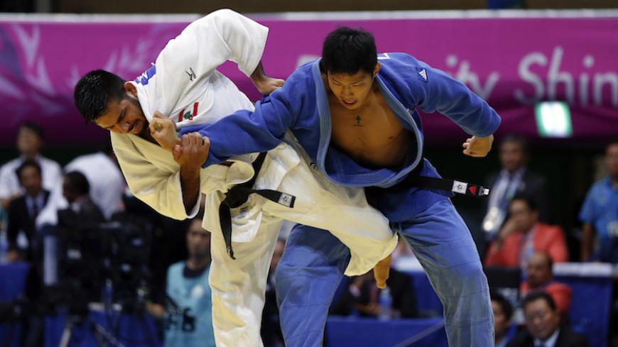 South Korea's Kim Jae-bum (blue) competes with Lebanon's Nacif Elias during their men's -81kg gold medal judo match at Dowon Gymnasium during the 17th Asian Games in Incheon September 21, 2014. REUTERS/Issei Kato (SOUTH KOREA  - Tags: SPORT JUDO) - RTR473MO