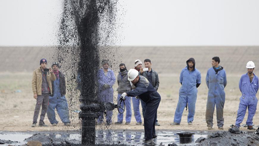 Iraqi workers stand near a pipeline as it ejects oil at Al Tuba oil field in Basra, southeast of Baghdad February 19, 2015. Iraq plans to increase its southern oil storage capacity to 15 million barrels by the end of 2015, to help cope with export bottlenecks caused by bad weather and to absorb rising production, a senior official said on Thursday. REUTERS/Essam Al-Sudani (IRAQ - Tag - Tags: BUSINESS ENERGY) - RTR4QAYT