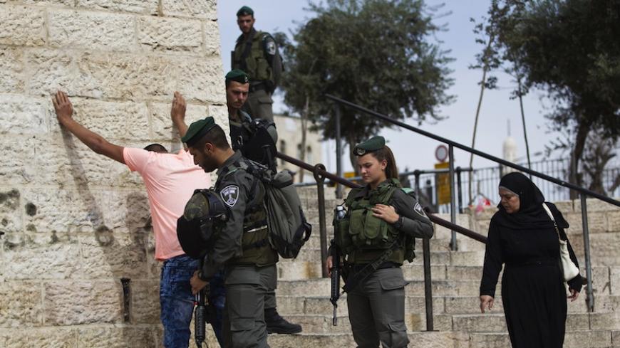 Israeli border policemen perform a security check on a Palestinian youth at Damascus Gate just outside Jerusalem's Old City before Friday prayers October 23, 2015. Palestinian factions called for mass rallies against Israel in the occupied West Bank and East Jerusalem in a "day of rage" on Friday, as world and regional powers pressed on with talks to try to end more than three weeks of bloodshed. Israeli authorities also lifted restrictions on Friday that had banned men aged under 40 from using the flashpoi