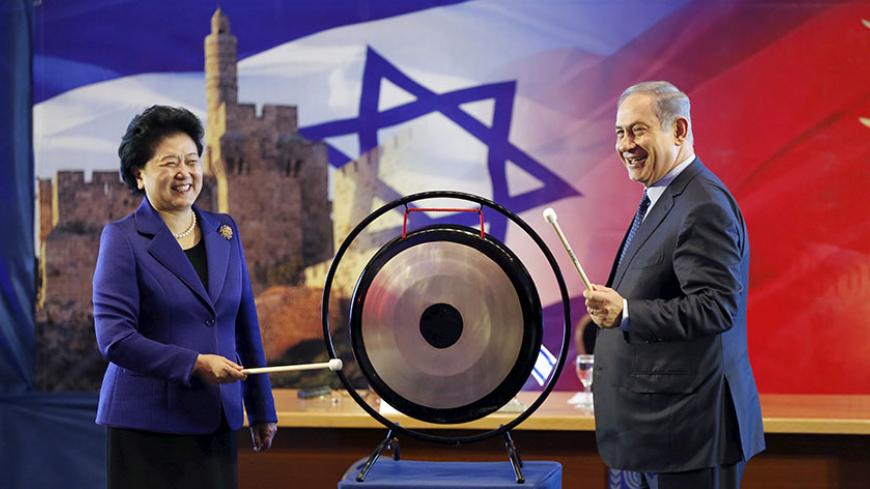 Israeli Prime Minister Benjamin Netanyahu (R) and Chinese Vice Premier Liu Yandong strike a gong during their joint news conference in Jerusalem March 29, 2016. REUTERS/Ronen Zvulun - RTSCN29