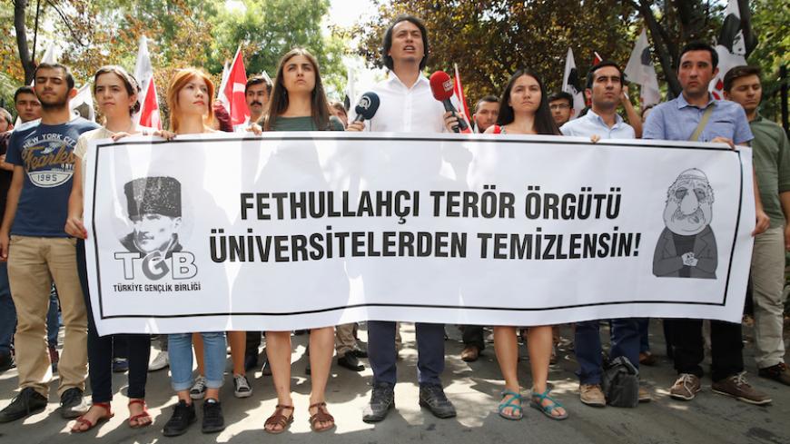 Members of the ultra-nationalist Turkish Youth Association (TGB) take part in a protest against academics close to U.S.-based cleric Fethullah Gulen in front of Ankara University in Ankara, Turkey, July 21, 2016. The banner reads "Universities should be cleansed from Fethullah's terrorist organisation". REUTERS/Baz Ratner - RTSJ0KC