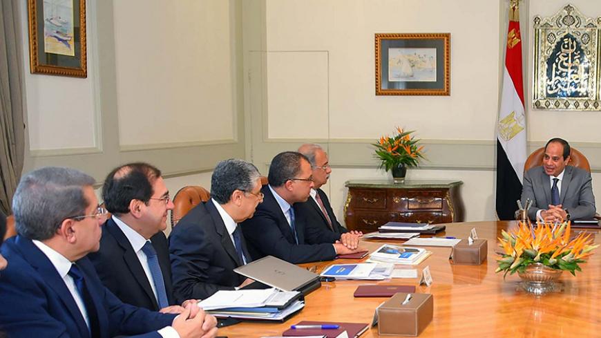 Egyptian President Abdel Fattah al-Sisi (R) attends a meeting with Egypt's Prime Minister Sherif Ismail (2nd R) and members of the government's Economic Ministerial Committee to discuss future economic indicators and figures of the general budget and the results of the talks with the International Monetary Fund (IMF) at the Ittihadiya presidential palace in Cairo, Egypt July 27, 2016 in this handout picture courtesy of the Egyptian Presidency. The Egyptian Presidency/Handout via REUTERS ATTENTION EDITORS - 
