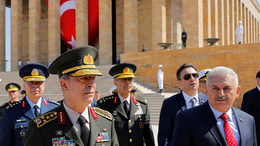 Turkey's Prime Minister Binali Yildirim (R), flanked by Chief of Staff General Hulusi Akar (L) and the country's top generals, leaves Anitkabir, the mausoleum of modern Turkey founder Mustafa Kemal Ataturk, after a wreath-laying ceremony ahead of a High Military Council meeting in Ankara, Turkey, July 28, 2016. REUTERS/Umit Bektas - RTSK1K6
