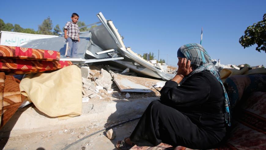 A Palestinian woman reacts after Israeli troops demolished her shed near the West Bank village of Um AlKhair, south of Hebron August 9, 2016. REUTERS/Mussa Qawasma - RTSM063