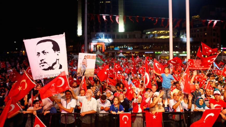 Supporters of Turkish President Recep Tayyip Erdogan wave national flags as they listen to him through a giant screen in Istanbul's Taksim Square, Turkey, August 10, 2016. REUTERS/Osman Orsal - RTSMIJJ