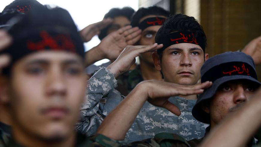 Iraqi Shi'ite fighters salute to the shrine of Sayeda Zeinab, the granddaughter of Prophet Mohammad, at Sayeda Zainab area in Damascus May 25, 2013. Picture taken May 25, 2013. REUTERS/ Alaa Al-Marjani (SYRIA - Tags: CIVIL UNREST POLITICS MILITARY CONFLICT) ) - RTX104SW