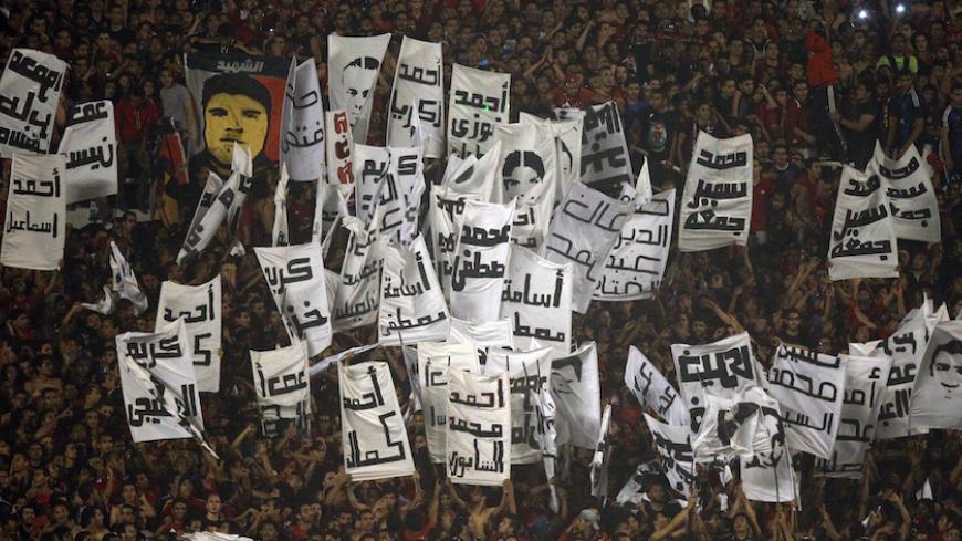 Fans of Egypt's Al-Ahli known as "Ultras" hold portraits with names of supporters who were killed in Port Said, during their African Champions League final soccer match against South Africa's Orlando Pirates at the Arab Contractors Stadium in Cairo November 10, 2013. Al Ahli's Mohamed Aboutrika underlined his status as the most successful player in African club competition over the last decade by scoring in a 2-0 final win over Orlando Pirates that clinched the African Champions League crown on Sunday. Port