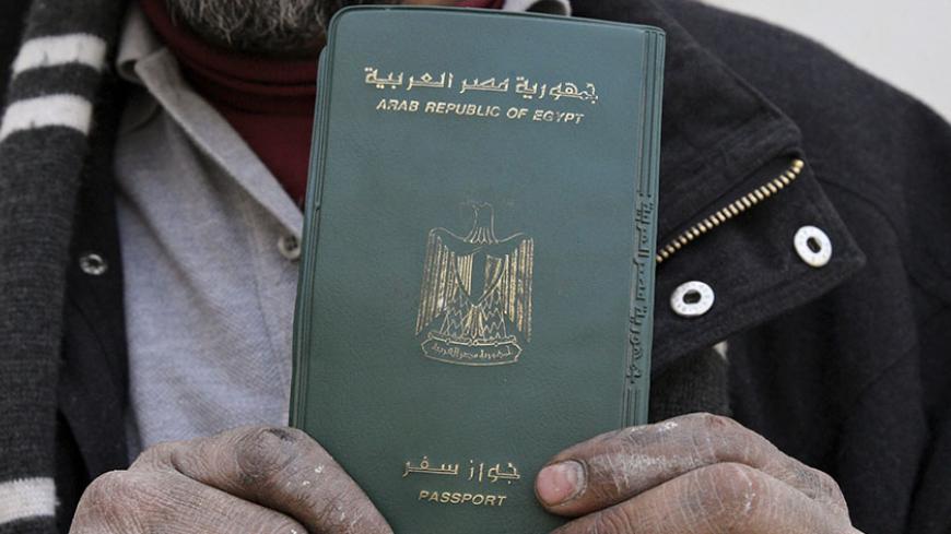 An Egyptian man shows his passport after voting in a referendum on his country's new constitution at the Egyptian embassy in Amman January 9, 2014. Egyptians living outside the country on Wednesday began voting in a referendum on the new constitution. The referendum marks the first time Egyptians have voted since the removal of President Mohamed Mursi in July, and is seen as much as a public vote of confidence on the roadmap and army chief Abdel Fattah al-Sisi as the constitution itself. REUTERS/Majed Jaber