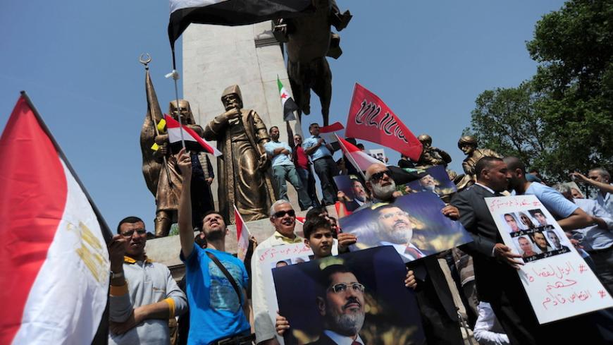 Pro-Islamist demonstrators hold Egyptian flags and posters of former President Mohamed Mursi during a protest in support of him at the courtyard of Fatih mosque in Istanbul, Turkey, May 17, 2015. An Egyptian court on Saturday sought the death penalty for former president Mohamed Mursi and 106 supporters of his Muslim Brotherhood in connection with a mass jail break in 2011. Mursi and his fellow defendants, including top Brotherhood leader Mohamed Badie, were convicted for killing and kidnapping policemen, a