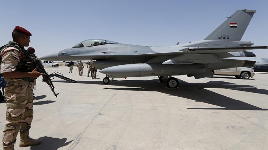 An Iraqi solider stands guard near a F-16 fighter jet during an official ceremony to receive four of these aircrafts from the U.S., at a military base in Balad, Iraq, July 20, 2015. REUTERS/Thaier Al-Sudani - RTX1L2B2