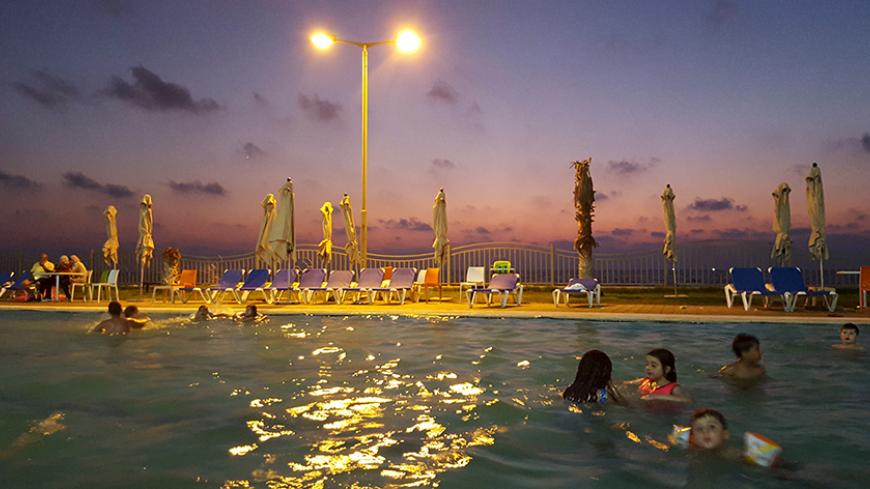 Palestinian children swim in a pool as they enjoy the warm weather with their families at the Blue Beach Resort in Gaza July 25, 2015. A luxurious new tourist resort has opened in the Gaza Strip, its manicured lawns, sparkling pool and private beach in stark contrast to the impoverished territory still struggling to recover from last year's war. The Blue Beach Resort, made up of 162 chalet-style rooms set among palm trees and overlooking the Mediterranean, hopes to become the "most significant tourist attra