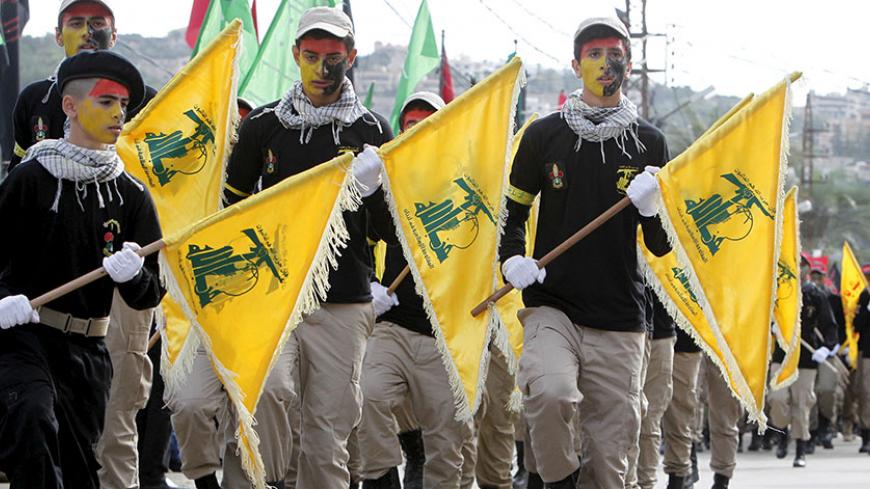 Lebanon's Hezbollah scouts carry their parties flag while marching at the funeral of three Hezbollah fighters who were killed while fighting alongside Syrian army forces in Syria in Nabatieh town, southern Lebanon, October 27, 2015. The fighters names are Hussein Hassan Shreifie, Ali al-Akbar Mohamad Khashfeh and Mohamad Saeed Fawaz. REUTERS/Ali Hashisho - RTX1TI38