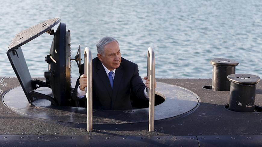 Israeli Prime Minister Benjamin Netanyahu climbs out after a visit inside the Rahav, the fifth submarine in the Israeli Navy's fleet, after it arrived in Haifa port January 12, 2016. The Dolphin-class submarines, widely believed to be capable of firing nuclear missiles, were manufactured in Germany and sold to Israel at deep discounts as part of Berlin's commitment to shoring up the security of the country set in part as a haven for Jews who survived the Holocaust.     REUTERS/Baz Ratner - RTX221FW
