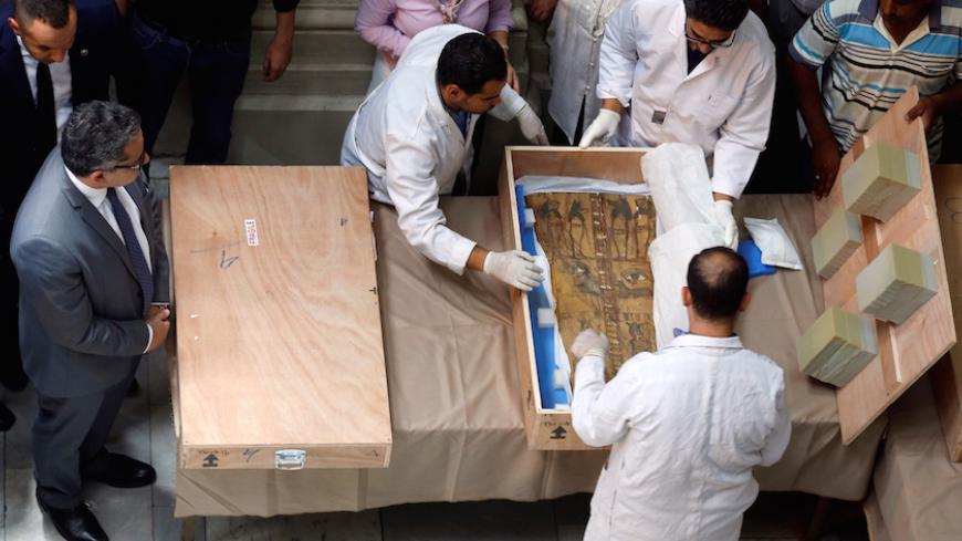 Egyptian Minister of Antiquities Khaled El Enany (L) and antiquities officials uncrate a sarcophagus lid during a ceremony after its repatriation from Israel at the Egyptian Museum in Cairo, Egypt June 21, 2016. REUTERS/Amr Abdallah Dalsh - RTX2HE90