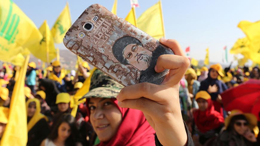 A Hezbollah supporter shows off a picture of Lebanon's Hezbollah leader Sayyed Hassan Nasrallah on her phone during a rally marking the 10th anniversary of the end of Hezbollah's 2006 war with Israel, in Bint Jbeil, southern Lebanon August 13, 2016. REUTERS/Aziz Taher - RTX2KKE3