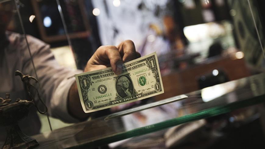 EDITORS' NOTE: Reuters and other foreign media are subject to Iranian restrictions on their ability to report, film or take pictures in Tehran.

A currency exchange dealer displays a U.S. one dollar note at the window of his shop in a shopping centre in northern Tehran October 3, 2010. Iran's currency, the rial, defied central bank attempts to revive its value on Sunday, remaining weak after falling 13 percent against the dollar last week. Morteza Nikoubazl (IRAN - Tags: BUSINESS POLITICS) - RTXSZ8M