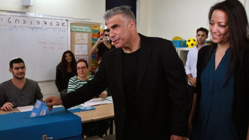 Israeli MP and chairperson of center-right Yesh Atid party, Yair Lapid, casts his ballot at a polling station with his wife Lihi (R) on March 17, 2015 in Tel Aviv. Voting polls opened for unpredictable elections to determine whether Israelis still want incumbent Prime Minister Benjamin Netanyahu as leader, or will seek change after six years. AFP PHOTO / GIL COHEN MAGEN        (Photo credit should read GIL COHEN MAGEN/AFP/Getty Images)