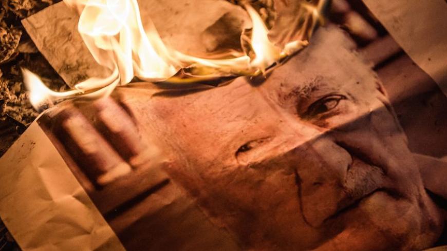 A picture taken on July 18, 2016 shows a poster picturing US-based preacher Fethullah Gulen burning during a Pro-Erdogan supporters rally at Taksim square in Istanbul on July 18, 2016 following the military failed coup attempt of July 15.
Turkish security forces on July 18 carried out new raids against suspected plotters of the botched coup against the rule of President Recep Tayyip Erdogan, as international concern grew over the scale of the crackdown. Thousands of pro-Erdogan supporters waving Turkish fla