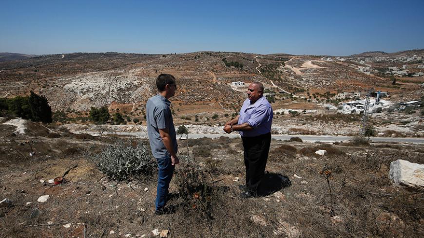 Fuad Maadi (R), a 60-year-old Palestinian man, speaks with Gilad Grossman of Israeli rights group Yesh Din, on September 11, 2016, as he stands on a hill in the West Bank Christian village of Taybeh overlooking land he says his family owns and on which houses from the nearby wildcat Jewish settlement of Amona might be relocated.
An Israeli court has ruled that the wildcat Jewish settlement of Amona, where live around 40 families in mainly caravan homes, is on Palestinian property and must be evacuated by De
