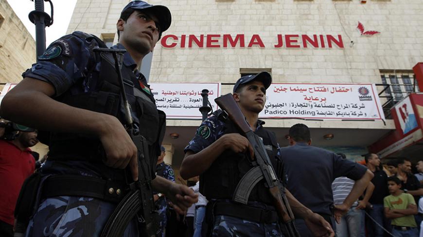 Palestinian police stand outside the Cinema Jenin movie theatre in the West Bank city of Jenin August 5, 2010. The only cinema in Jenin, closed for more than 20 years, reopened on Thursday following two years of restoration work.  REUTERS/Ammar Awad (WEST BANK - Tags: SOCIETY IMAGES OF THE DAY) - RTR2H2GC