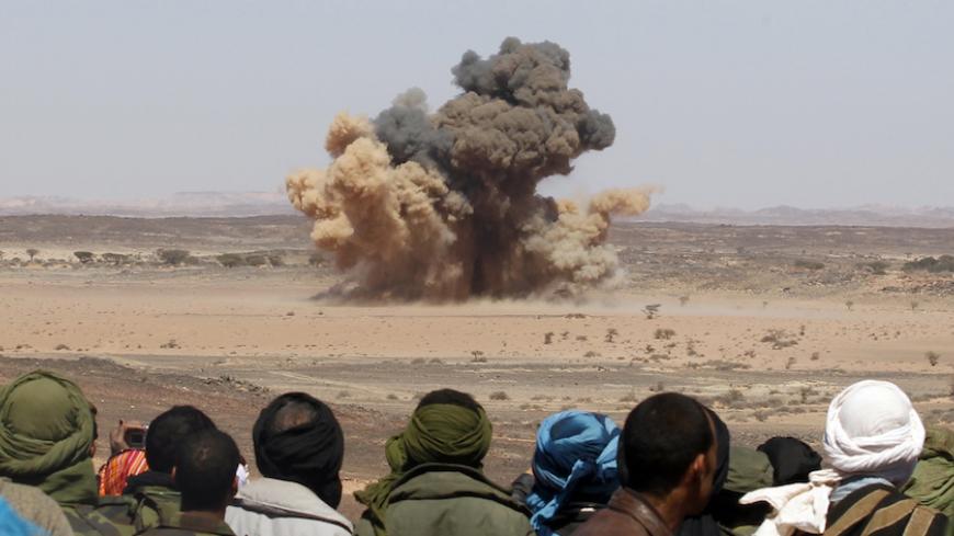 Sahrawis watch a mine explode during a demonstration organised by officials from the Saharawi Arab Democratic Republic (SADR) to show the hazards of mined territory near Tifariti, in the Sahara desert in southwestern Algeria, February 28, 2011. Over 150,000 Sahrawis live in several refugee camps dispersed in the Algerian desert 35 years after Morocco annexed the disputed territory of Western Sahara. REUTERS/Juan Medina (ALGERIA - Tags: POLITICS CIVIL UNREST MILITARY IMAGES OF THE DAY) - RTR2J9CS