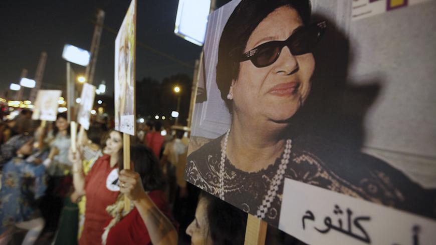 Egyptian women carry a picture of late Egyptian singer Oum Kalthoum during a protest supporting women's rights in the constitution and protesting against harassment against women and child marriage, in front of the presidential palace in Cairo October 4, 2012. REUTERS/Amr Abdallah Dalsh  (EGYPT - Tags: POLITICS CIVIL UNREST) - RTR38T58