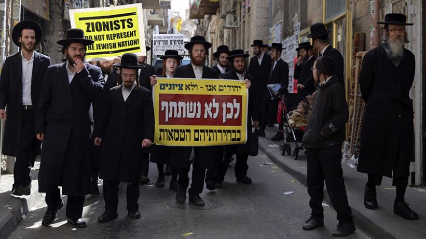 Members of Neturei Karta, a fringe Jewish Ultra-Orthodox movement within the anti-Zionist bloc, take part in a protest against Israel's parliamentary election in Jerusalem March 17, 2015. Millions of Israelis voted on Tuesday in a tightly fought election, with Prime Minister Benjamin Netanyahu facing an uphill battle to defeat a strong campaign by the centre-left opposition to deny him a fourth term in office. The sign reads, "We are Jews, not Zionists. That's why we will not participate in their impure ele