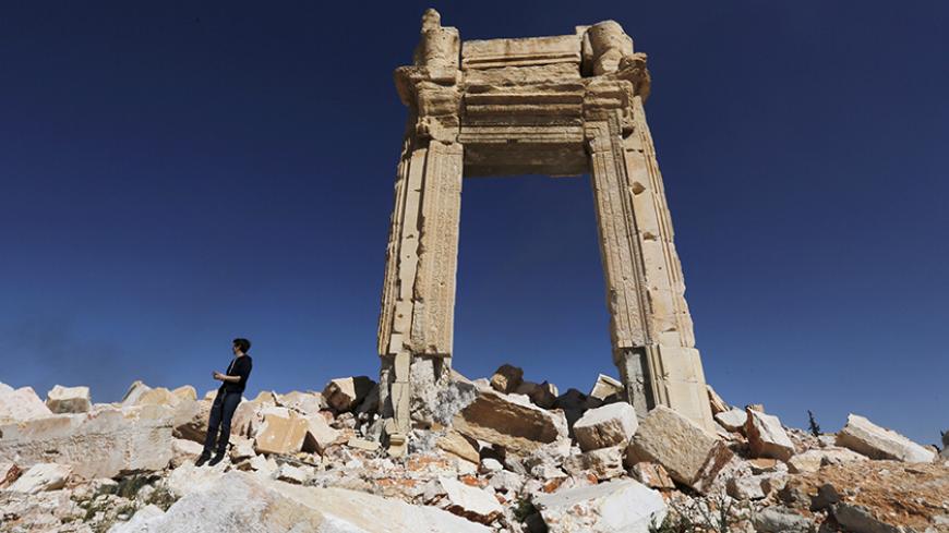 A journalist stands at the remains of the Temple of Bel in the historic city of Palmyra, in Homs Governorate, Syria April 1, 2016. REUTERS/Omar Sanadiki  SEARCH "PALMYRA SANADIKI" FOR THIS STORY. SEARCH "THE WIDER IMAGE" FOR ALL STORIES - RTSD71B