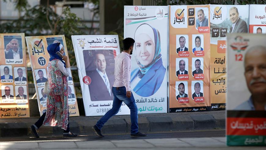 People walk past electoral posters for parliamentary candidates, ahead of the general elections to be held on September 20,  in Amman, Jordan, September 16, 2016. REUTERS/Muhammad Hamed - RTSO224