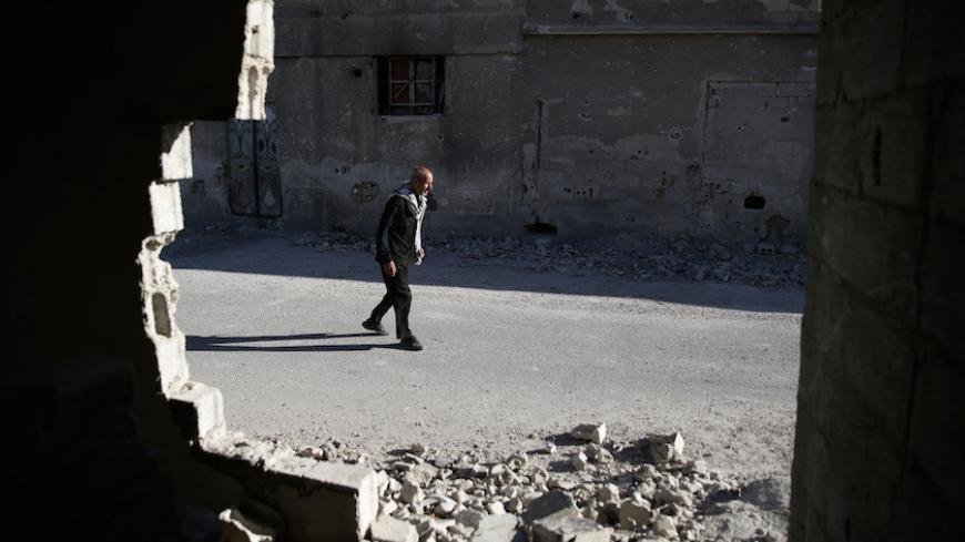 A man walks near damaged buildings in the rebel held Douma neighbourhood of Damascus, Syria September 22, 2016. REUTERS/Bassam Khabieh - RTSP0DL