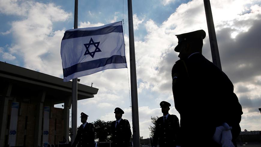 Israeli presidential guards stand next to national flag which was lowered to half mast during a ceremony marking the death of former Israeli President Shimon Peres, at the Knesset, the Israeli parliament in Jerusalem September 28, 2016. REUTERS/Ronen Zvulun - RTSPUZ8