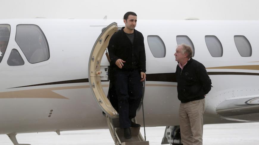 Former U.S. Marine Amir Hekmati, recently released from an Iranian prison, steps out of the plane piloted by Mike Karnowski (R), as he arrives at an airport in Flint, Michigan January 21, 2016.      REUTERS/Rebecca Cook - RTX23GEV