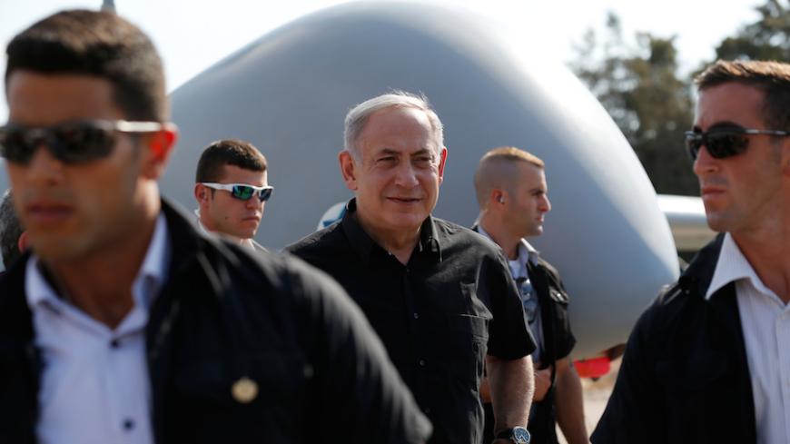 Israeli Prime Minister Benjamin Netanyahu (C) is surrounded by bodyguards during his visit to the Tel Nof airforce base in southern Israel August 17, 2016. REUTERS/Amir Cohen  - RTX2LITQ