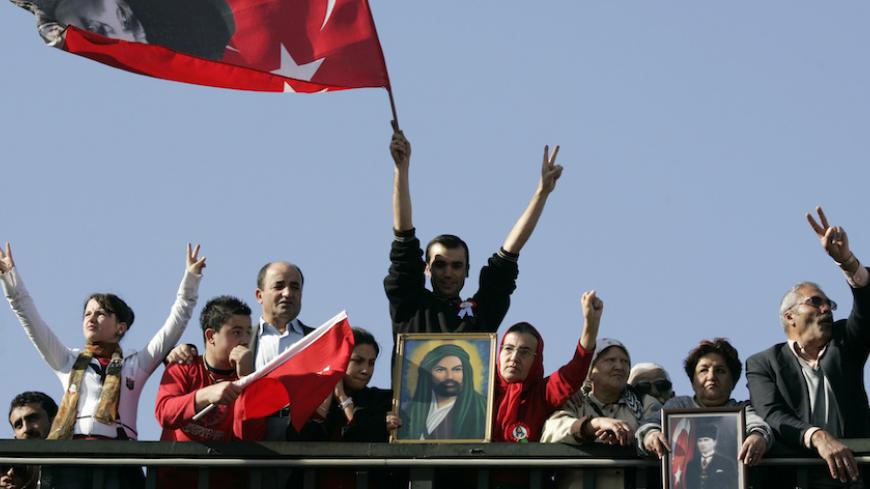 Turkish Alevis make v-signs, hold national flags and portraits of Mustafa Kemal Ataturk and Hadrat Ali Ibn Abu Talib, son-in-law of Prophet Mohammed, during a rally in Ankara November 9, 2008.  Thousands of Turkish Alevis marched in Ankara on Sunday in their first massive demonstration to call for an end to discrimination by the government and compulsory religious classes.  REUTERS/Umit Bektas (TURKEY) - RTXAF2X