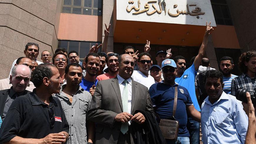 Egyptian lawyer and leftist opposition figure Khaled Ali (C) stands among people outside the State Council's building, Egypt's highest administrative court, in Cairo on June 26, 2016, after the court postponed to July 3 the hearing of the government's appeal against the decision to block the controversial handover of two uninhabited Red Sea islands to Saudi Arabia.
The deal over the islands of Tiran and Sanafir prompted some of the largest public protests in two years when it was signed in April. The countr