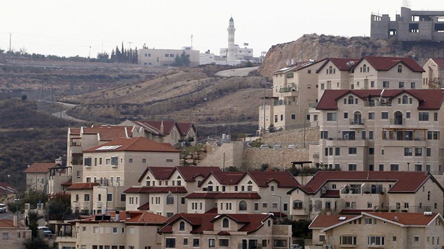 A mosque in the Palestinian West Bank village of Abdullah Ibrahim (rear) is seen behind houses in West Bank Jewish settlement of Efrat, near Bethlehem December 22, 2011. Israel on Wednesday said four European U.N. Security Council members should support a resumption of stalled Israeli-Palestinian peace talks because their criticism of the Jewish state, including it's construction of new settlements, could sideline them from negotiations. REUTERS/Baz Ratner (WEST BANK - Tags: POLITICS) - RTR2VJOQ