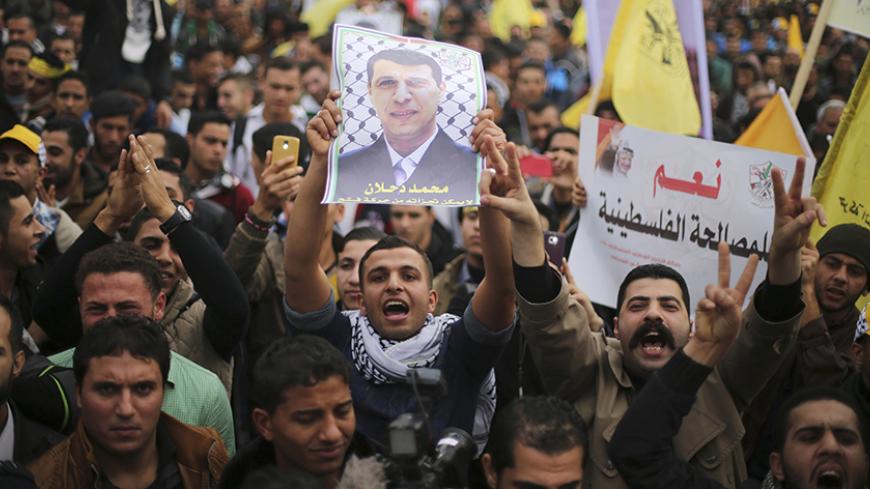 A Palestinian supporter of former head of Fatah in Gaza, Mohammed Dahlan, holds a poster depicting Dahlan during a protest against Palestinian President Mahmoud Abbas in Gaza City December 18, 2014. Dahlan, who lives in exile in the Gulf, is a powerful political foe of Abbas. 
REUTERS/Mohammed Salem (GAZA - Tags: POLITICS CIVIL UNREST) - RTR4IJ8R
