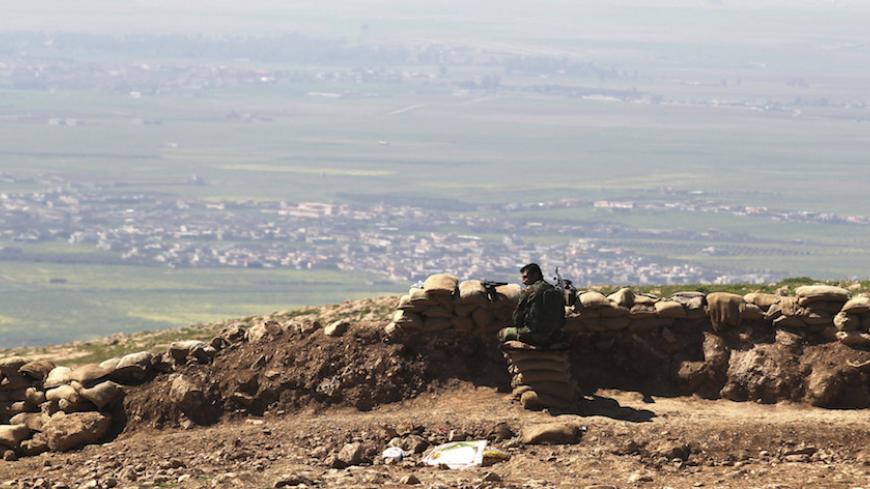 A member of the Kurdish Peshmerga forces guards a security point on Bashiqa mountain, overlooking Islamic State held territories of Mosul, 12 km northeast of Mosul City, March 7, 2015.  REUTERS/Asmaa Waguih (IRAQ - Tags: POLITICS MILITARY CONFLICT) - RTR4SF1D