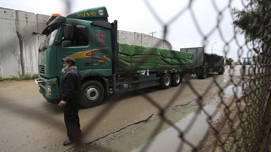 A Palestinian policeman stands guard as a truck loaded with fruits and vegetables waits to cross into the Israeli side of the Kerem Shalom crossing in Rafah in the southern Gaza Strip  March 12, 2015. Israel imported its first fruit and vegetables from the Gaza Strip in almost eight years on Thursday, in a partial easing of an economic blockade maintained since the Islamist group Hamas seized control of the Palestinian territory. Twenty-seven tonnes of tomatoes and five tonnes of eggplants were trucked acro