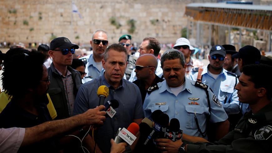 Israel's Public Security Minister Gilad Erdan (3rd L) and police commissioner Roni Alsheich (3rd R) speak to members of the media at the Western Wall in Jerusalem's Old City as Palestinians mark the first Friday of the holy fasting month of Ramadan on the nearby compound known to Muslims as Noble Sanctuary and to Jews as Temple Mount June 10, 2016. REUTERS/Amir Cohen - RTSGVL8