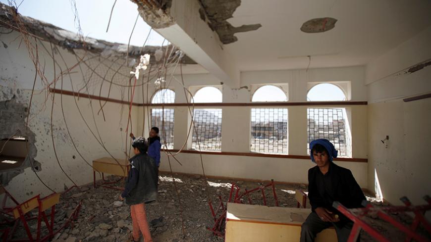 Boys are pictured in a damaged class of their school which was hit by Saudi-led air strikes last year, as schools open this week in Sanaa, the capital of war-torn Yemen October 5, 2016.  REUTERS/Khaled Abdullah - RTSQVP2