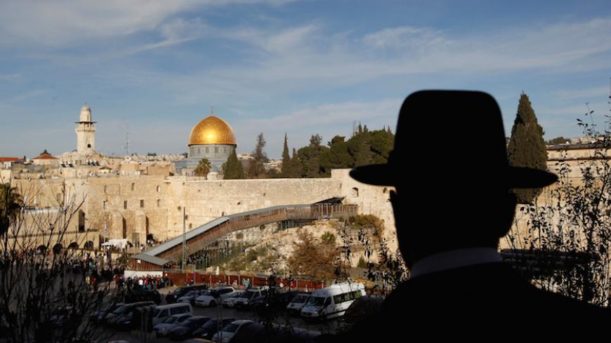 An ultra-Orthodox Jewish man stands at a view-point overlooking a wooden ramp (C) leading up from Judaism's Western Wall to the sacred compound known to Muslims as the Noble Sanctuary and to Jews as Temple Mount, where the al-Aqsa mosque and the Dome of the Rock shrine stand, in Jerusalem's Old City December 12, 2011. REUTERS/Ronen Zvulun/File Photo - RTSS5BJ