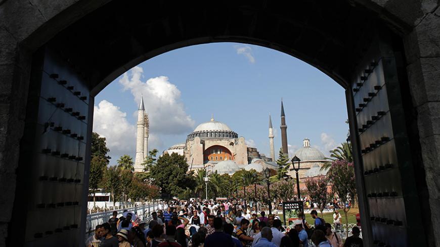 Local and foreign visitors, with the Byzantine-era monument of Hagia Sophia in the background, stroll at Sultanahmet square in Istanbul August 23, 2013. The number of foreign visitors arriving in Turkey grew at its slowest pace for eight months in July, as the impact of anti-government protests and the Muslim fasting month of Ramadan took their toll, data showed on Friday. Foreign arrivals rose 0.48 percent year-on-year last month to 4.59 million people, according to the Tourism Ministry figures, the lowest