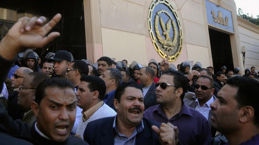Police officers shout slogans as they take part in a sanctioned protest outside the Interior Ministry building in Cairo December 8, 2013. The police officers were demanding for a raise in salary and promotion, according to local media. Egypt's new protest law has deepened unrest in the most populous Arab state and it gives the Interior Ministry the right to ban any meeting of more than 10 people in a public place. REUTERS/Stringer (EGYPT - Tags: POLITICS CIVIL UNREST LAW) - RTX169PG